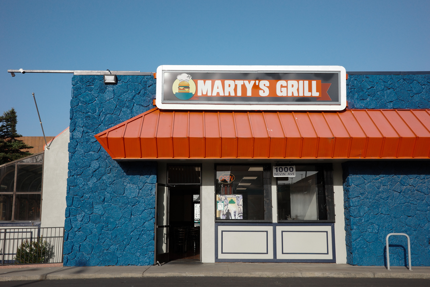 A blue and orange restaurant building that says Marty's Grill
